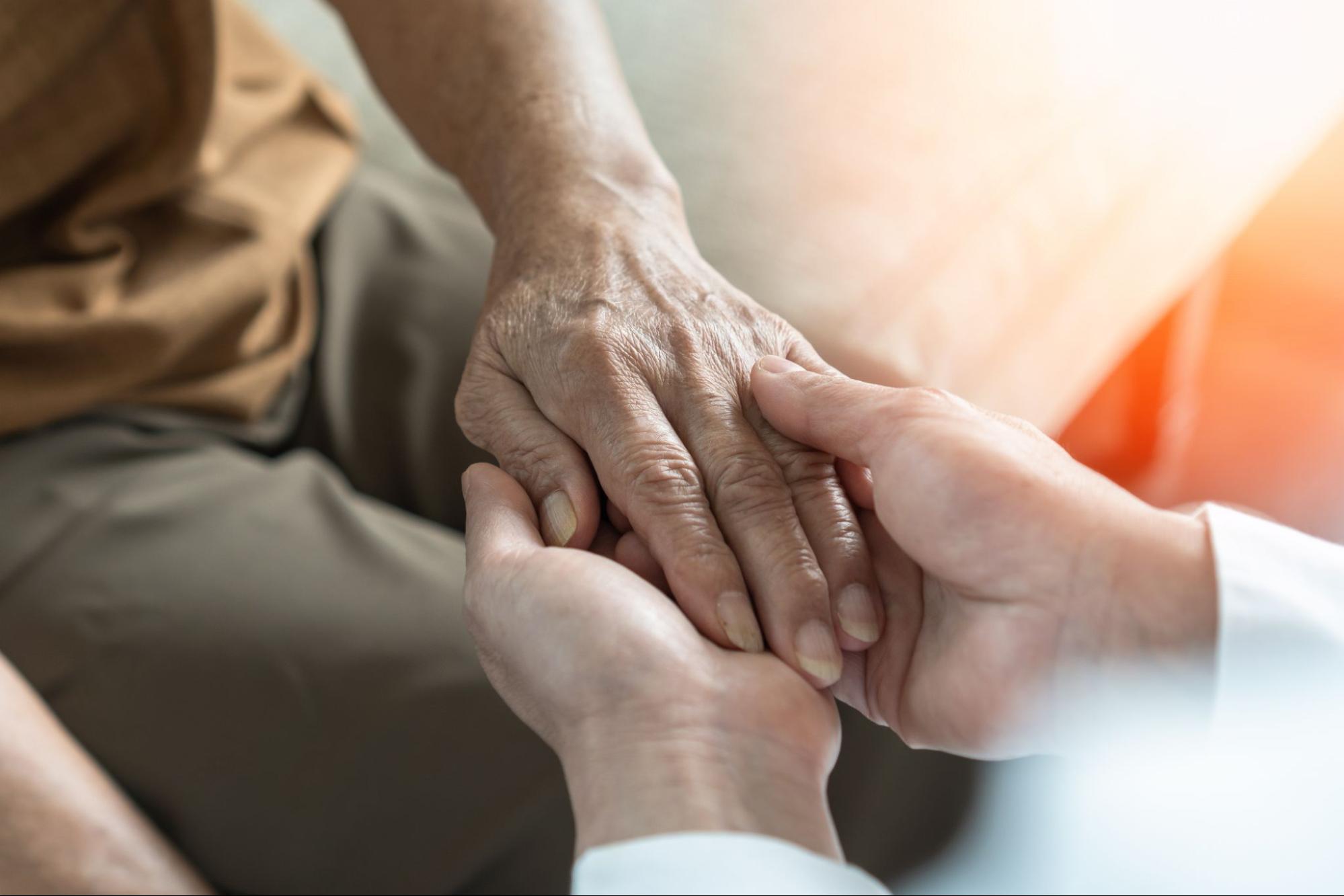 Hands hold each other for support during episodes of chronic pain.