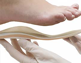 A  foot stepping onto a custom orthotic.