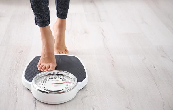 A person stepping onto a scale.