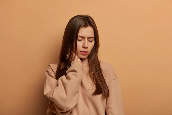 A woman holding her neck in pain.