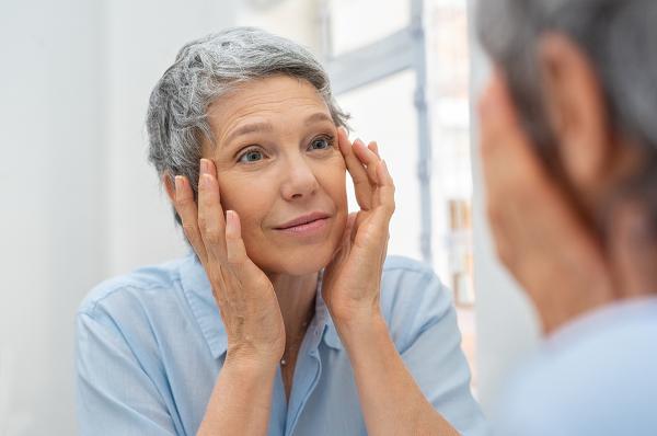 An older woman looking in the mirror.