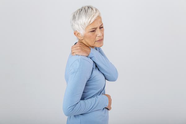 A woman holder her shoulder in pain.