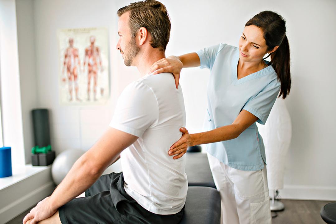 A chiropractor working with a patient.